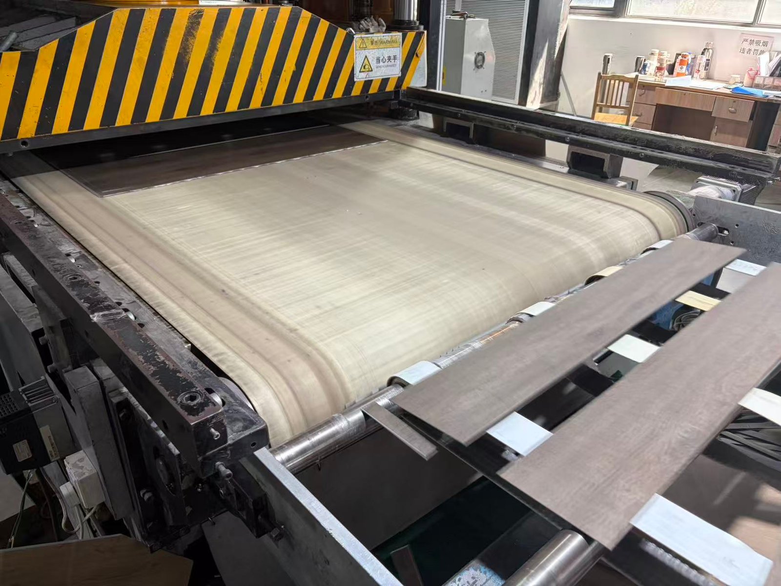 LVT flooring sheets moving through the shape-stamping production line