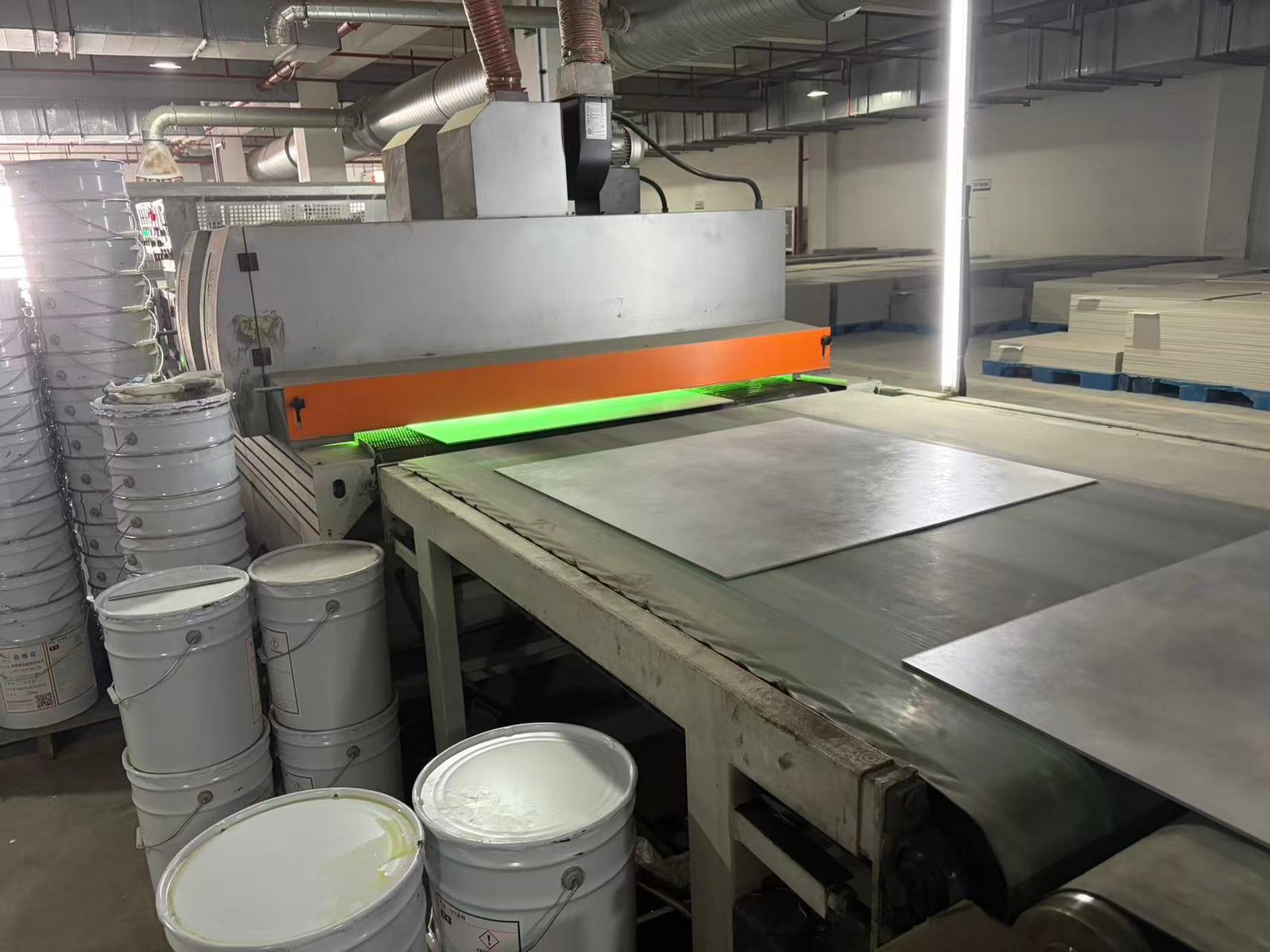 SPC flooring boards passing under the UV coating line