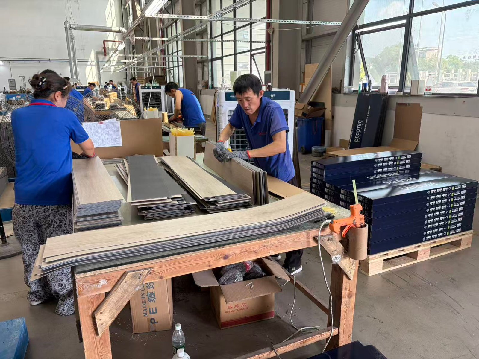 Workers packing finished SPC and LVT flooring cartons at the Ecoflors production base